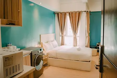 a small bedroom with a bed and a window at I Suites Hotel Malate in Malate