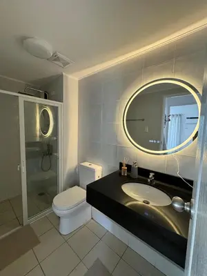 a bathroom with a sink and a toilet and a mirror at Modern Minimalist Luxe Retreat 2 Bedroom with parking in Manila