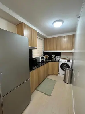 a kitchen with wooden cabinets and a refrigerator at Modern Minimalist Luxe Retreat 2 Bedroom with parking in Manila