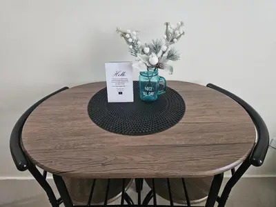 a table with a blue mug and flowers on it at Entire Studio Unit Classio De Condotel at Urban Deca Cubao in Manila