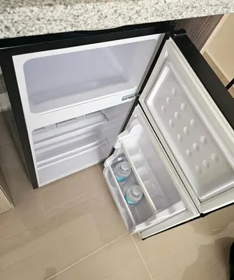 an empty refrigerator with its door open in a kitchen at Entire Studio Unit Classio De Condotel at Urban Deca Cubao in Manila