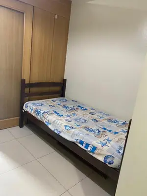 a small bed in a room with a bedspread at Sebby's staycation at Shell MOA in Manila