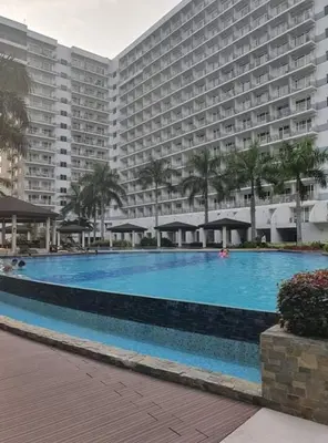 a large swimming pool in front of a large building at Sebby's staycation at Shell MOA in Manila