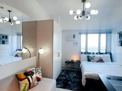 a room with two beds and a couch and a mirror at 1BR Condotel with Balcony at SM Light Residences #LT01-1 in Manila