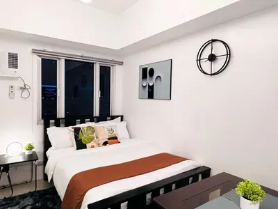 a bedroom with a bed and a clock on the wall at 1BR Condotel with Balcony at SM Light Residences #LT01-1 in Manila