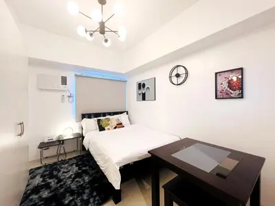 a bedroom with a bed and a table in it at 1BR Condotel with Balcony at SM Light Residences #LT01-1 in Manila