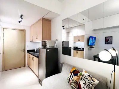 a small kitchen with a couch and a refrigerator at 1BR Condotel with Balcony at SM Light Residences #LT01-1 in Manila
