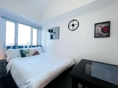 a white bedroom with a bed and a table at 1BR Condotel with Balcony at SM Light Residences #LT01-1 in Manila