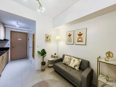 a living room with a couch and a kitchen at 1BR Condotel with Balcony at SM Light Residences #LT03-1 in Manila