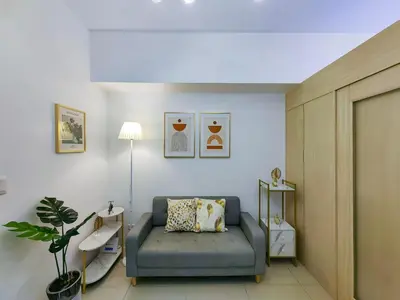 a living room with a blue couch in a room at 1BR Condotel with Balcony at SM Light Residences #LT03-1 in Manila