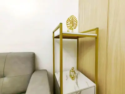 a room with a couch and a shelf with a clock at 1BR Condotel with Balcony at SM Light Residences #LT03-1 in Manila