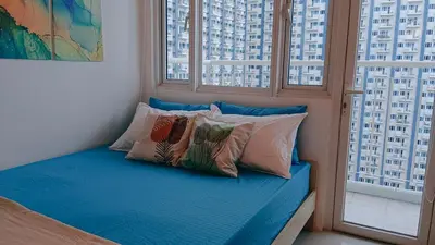 a blue bed with pillows in a room with windows at 1BR Condotel with Balcony at SM Light Residences #LT04-1 in Manila