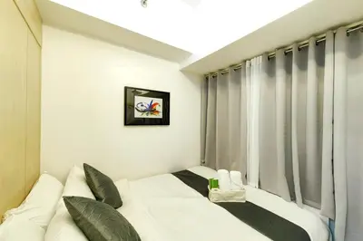 a bedroom with a bed and a window at 1BR Condotel with Balcony at SM Light Residences #LT05-1 in Manila