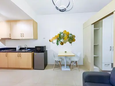 a kitchen with a table and a small table and chairs at 1BR Condotel with Balcony at SM Light Residences #LT06-1 in Manila