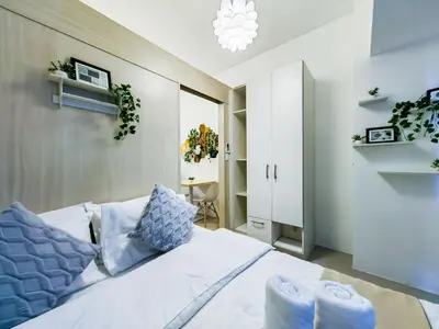 a bedroom with a white bed with blue pillows at 1BR Condotel with Balcony at SM Light Residences #LT06-1 in Manila