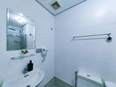 a white bathroom with a sink and a mirror at 1BR Condotel with Balcony at SM Light Residences #LT06-1 in Manila