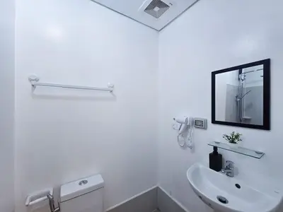 a white bathroom with a sink and a mirror at 1BR Condotel with Balcony at SM Light Residences #LT07-1 in Manila