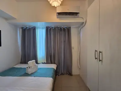 a small room with two beds and a window at 1BR Condotel with Balcony at SM Light Residences #LT07-1 in Manila