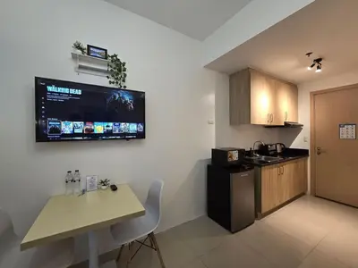 a kitchen with a table and a television on the wall at 1BR Condotel with Balcony at SM Light Residences #LT07-1 in Manila