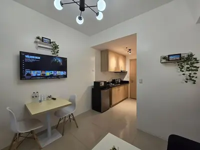 a living room with a table and a kitchen at 1BR Condotel with Balcony at SM Light Residences #LT07-1 in Manila