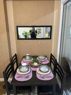 a person taking a picture of a table with plates and dishes at AZURE BICUTAN-MAUI 1631 City View in Manila
