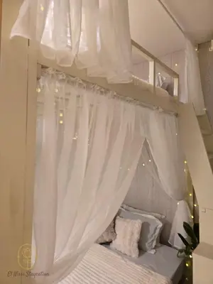 a bedroom with a canopy bed with white curtains at El Nissi Staycation, The Farmhouse Suite, Enchanted Kingdom in Santa Rosa
