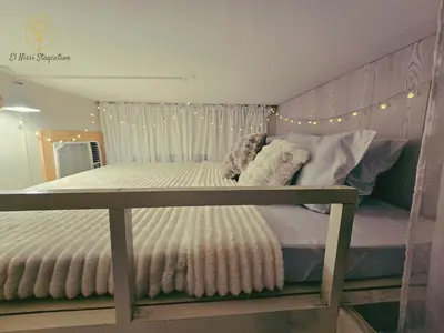 a bed in a room with lights on it at El Nissi Staycation, The Farmhouse Suite, Enchanted Kingdom in Santa Rosa