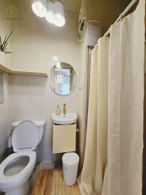 a bathroom with a toilet and a sink and a mirror at El Nissi Staycation, The Farmhouse Suite, Enchanted Kingdom in Santa Rosa
