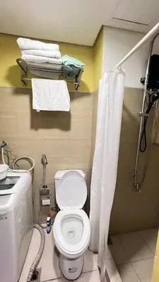 a bathroom with a white toilet and a shower at STARR VACATION Condo in Manila