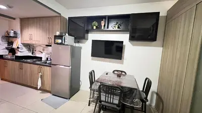 a kitchen with a table and a refrigerator at STARR VACATION Condo in Manila