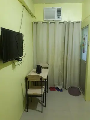 a room with a table and a tv and a chair at D and A Transient Inn Taguig in Taguig