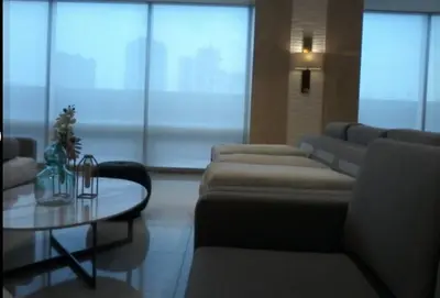 a living room with couches and a coffee table and a tableablish at La Maison Breeze Residence in Manila