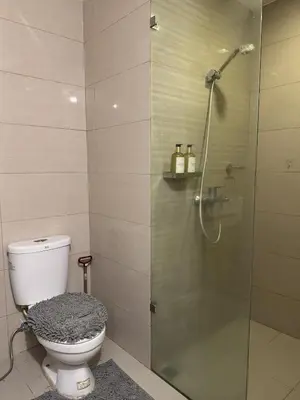 a bathroom with a toilet and a glass shower at Landscape view and sea view 1BR near Airport in Manila