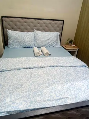 a bedroom with a bed with two slippers on it at La Maison Breeze Residence in Manila