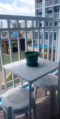 a bowl on a table on a balcony with two chairs at La Maison Breeze Residence in Manila