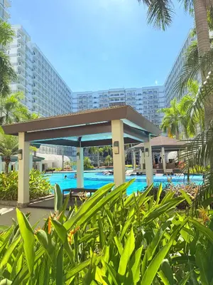 a pool with a gazebo in front of a building at Shell Residences MOA Prime - Paul in Manila