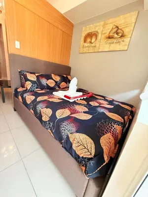 a bed with a tray on top of it at Shell Residences MOA Prime - Paul in Manila