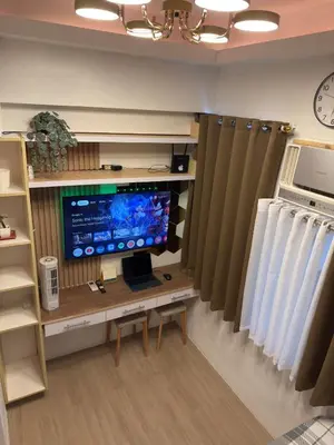 a room with a desk with a tv and a monitor at Bachelor's Crib-1 Alabang in Manila