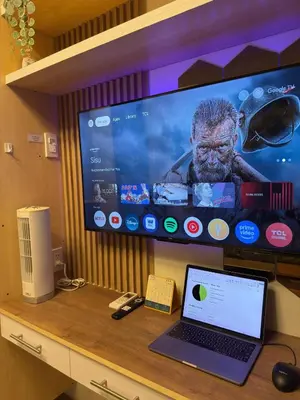 a laptop computer sitting on a desk with a tv at Bachelor's Crib-1 Alabang in Manila