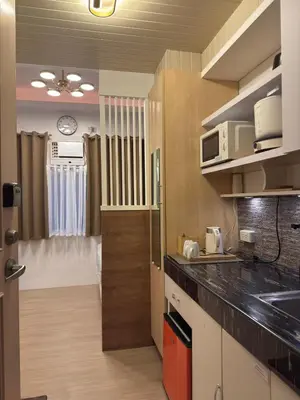 a kitchen with black counter tops and a room at Bachelor's Crib-1 Alabang in Manila