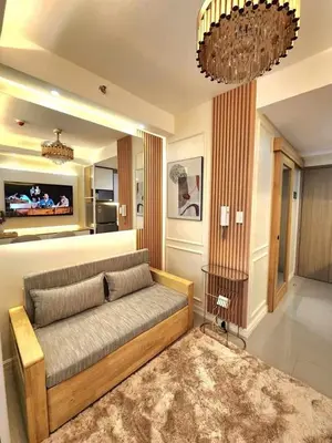a living room with a couch and a tv at Exquisite space in Manila