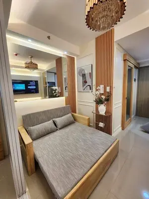 a bedroom with a bed and a living room at Exquisite space in Manila