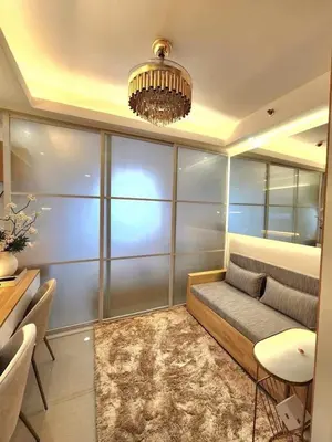 a living room with a couch and a chandelier at Exquisite space in Manila