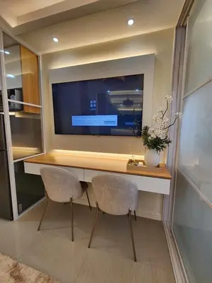 a room with a desk with two chairs and a tv at Exquisite space in Manila