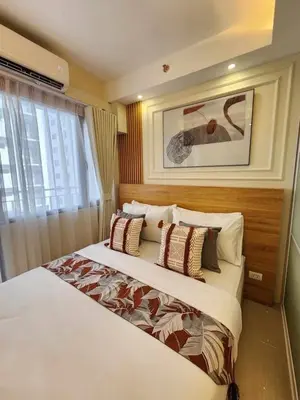 a bedroom with a large white bed with pillows at Exquisite space in Manila