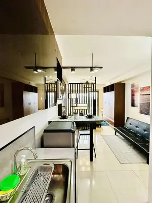 a kitchen with a sink and a table in it at Minimalist Urban Loft in Manila