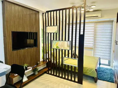 a bedroom with a bed and a tv in a room at Minimalist Urban Loft in Manila