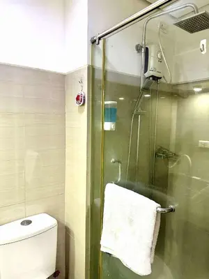 a bathroom with a toilet and a glass shower at Minimalist Urban Loft in Manila
