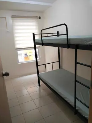 two bunk beds in a room with a window at Angels Pad in Manila