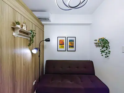 a living room with a couch and a lamp at 1BR Condotel with Balcony at FAME Residences #FM08-1 in Manila